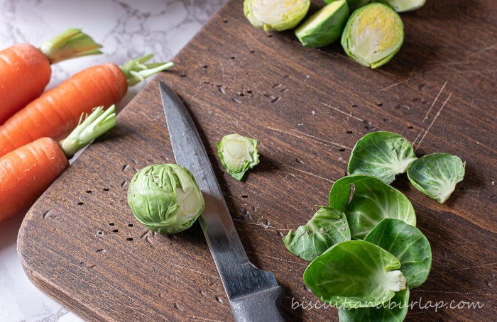 raw brussel sprouts on board with knife