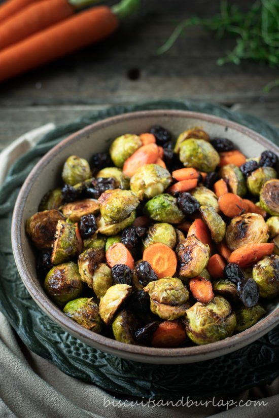 vertical shot of a bowl of roasted brussel sprouts with carrots