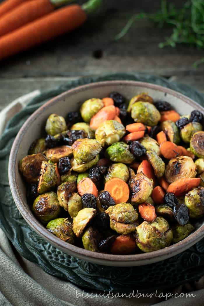 vertical shot of a bowl of roasted brussel sprouts with carrots