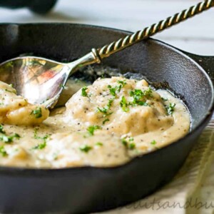 chicken in skillet with pan sauce.