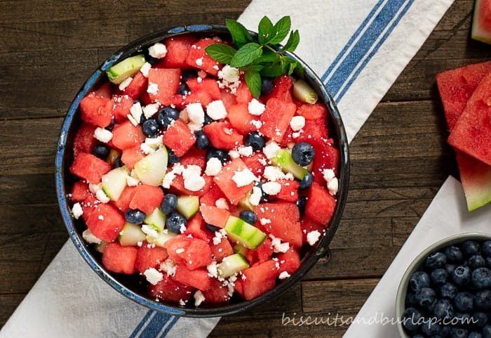 watermelon salad in bowl on white cloth with blue stripe