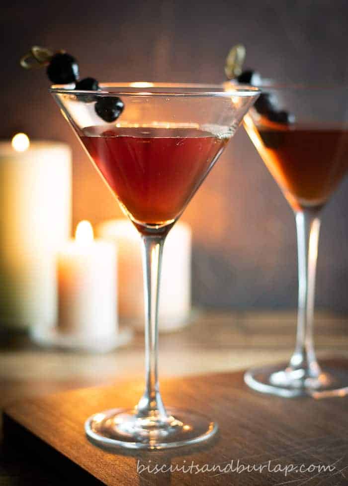 Bourbon gifts for Dad- bourbon, martini glass, and luxardo cherries with candles in background