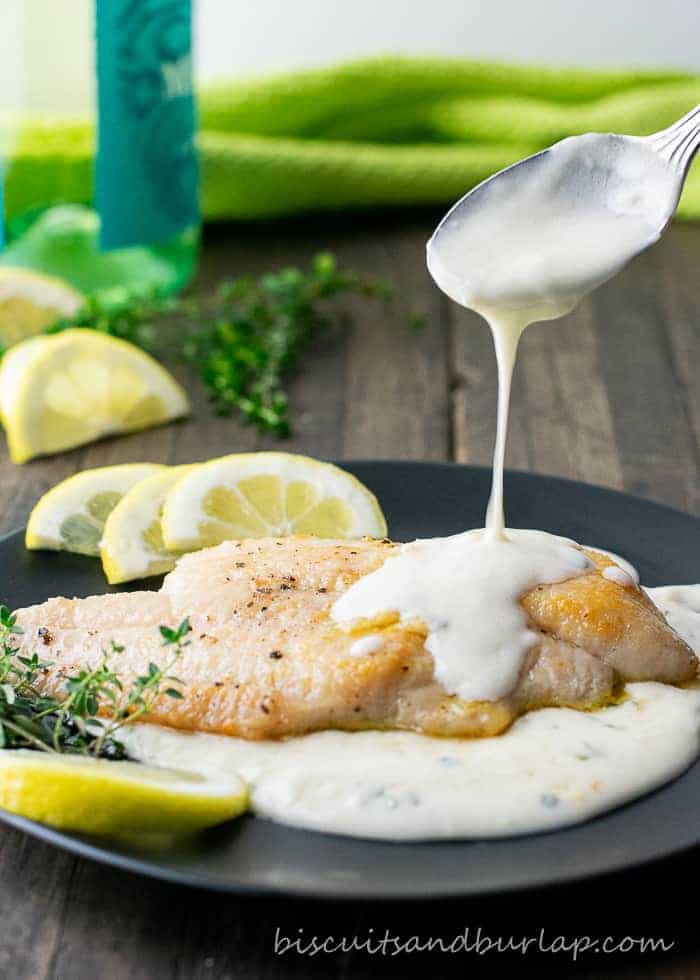 catfish on plate with sauce being spooned over