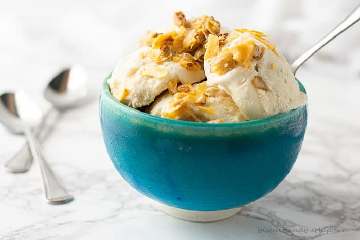 horizontal shot of ice cream in blue bowl with pecan brittle