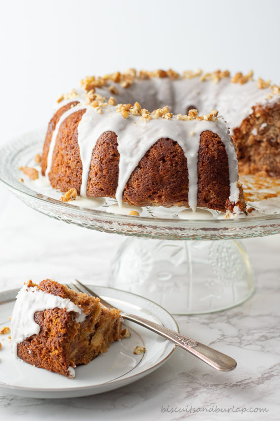 apple cider coffee cake on cake stand with slice on plate