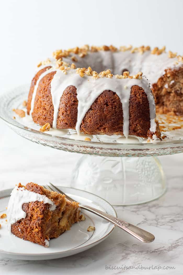 apple cider coffee cake on cake stand with slice on plate