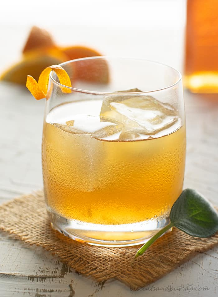 bourbon cocktail with oranges & honey bottle in background