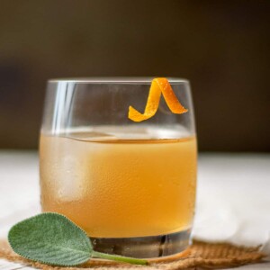 bourbon cocktail with orange garnish.