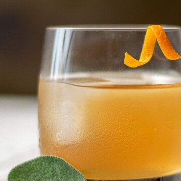 bourbon cocktail with orange garnish.