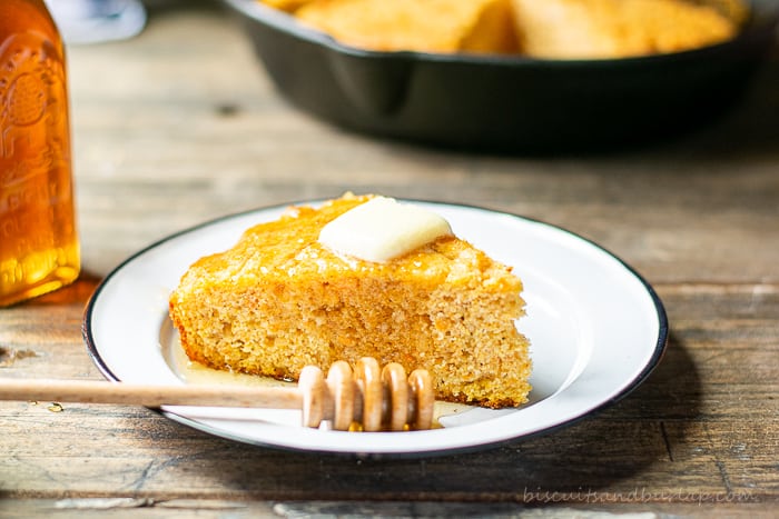 slice of sweet potato cornbread on plate with honey and butter on top