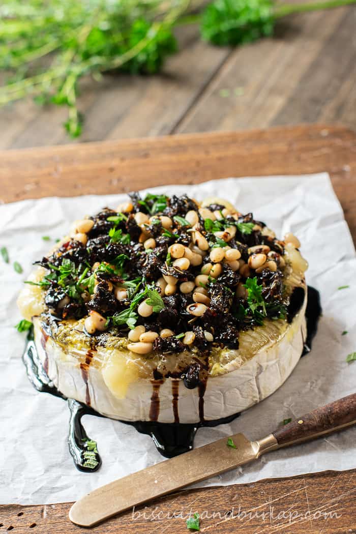 baked brie on parchment paper with balsamic drizzle