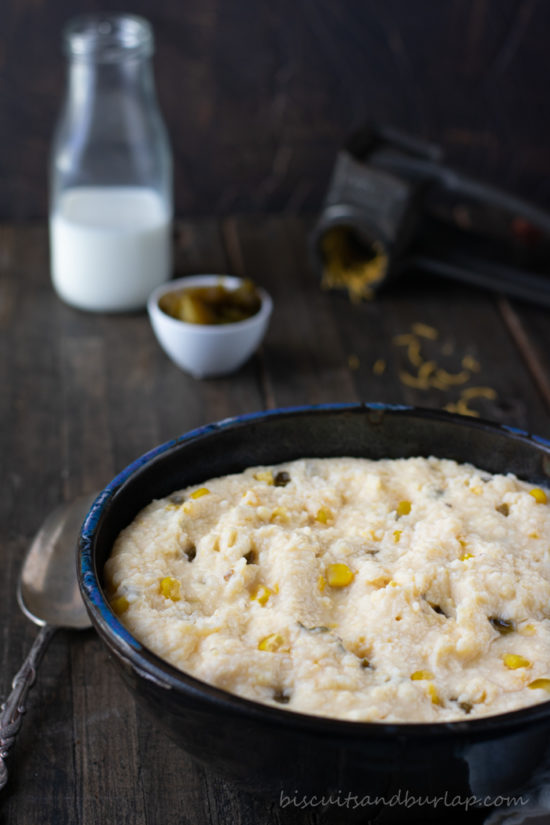 vertical shot of grits in bowl with cream behind