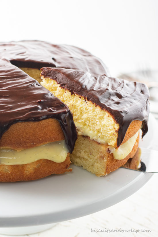 slice of boston cream pie being taken out of whole cake