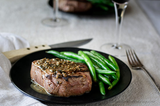 horizontal shot of filet mignon sauce over steak