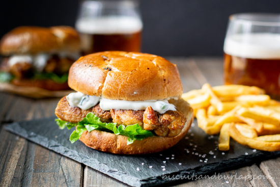 chicken sandwich on slate with fries
