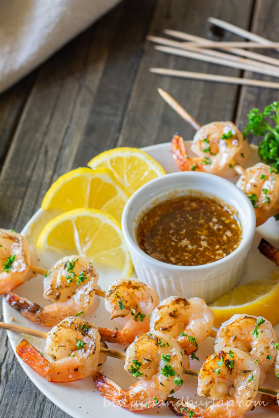 grilled shrimp skewers with sauce & lemons