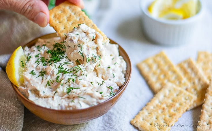 cracker being dipped in smoked fish dip