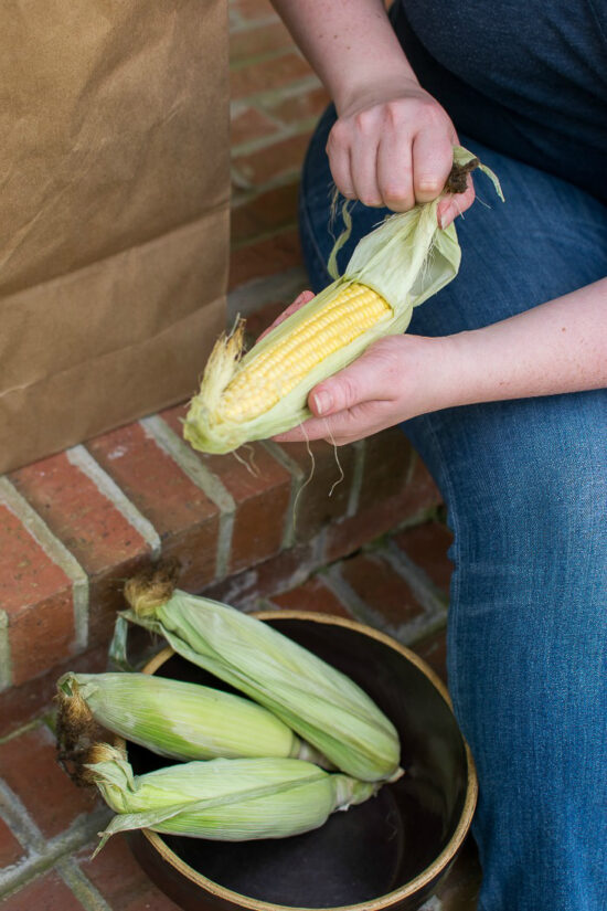 person shucking corn