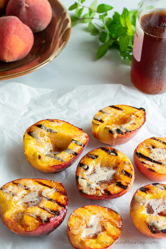 grilled peaches with syrup behind