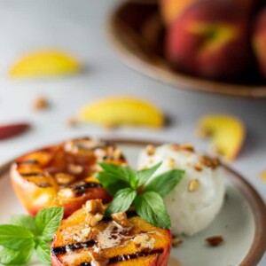 grilled peaches on plate with mint leaves