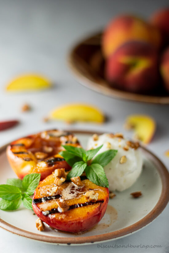 grilled peaches on plate with mint leaves