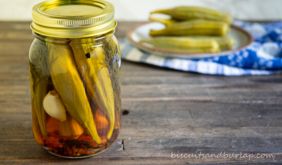 pickled okra in jar with a few on plate behind