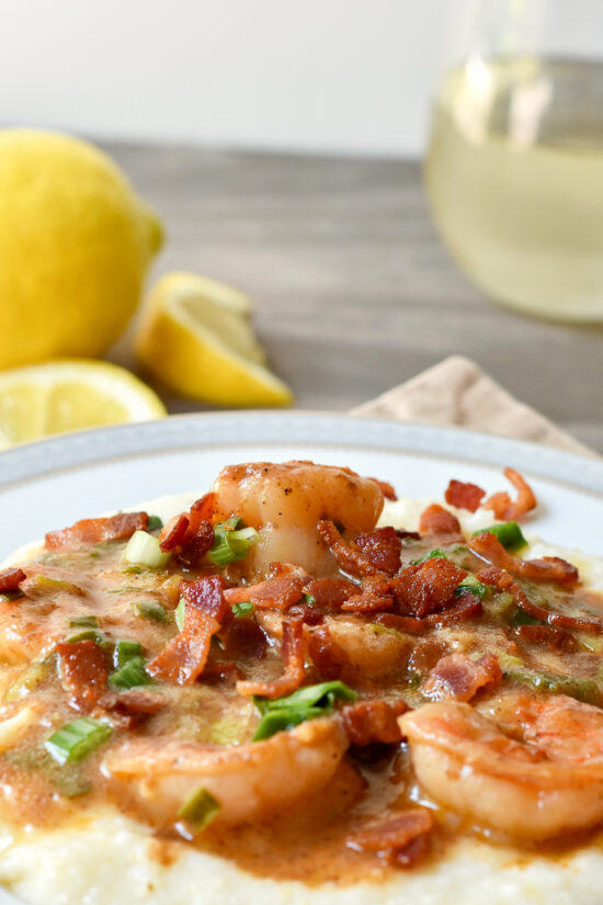 shrimp & grits with wine and lemon behind