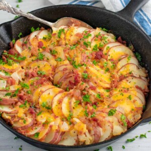skillet of sliced potatoes with topping.