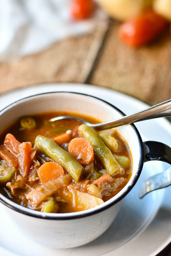 vegetable beef soup in cup with spoon