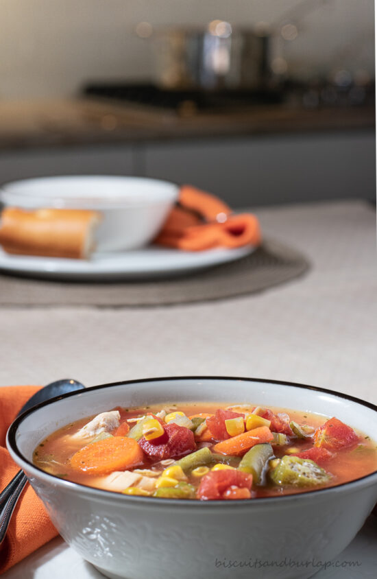 bowl of soup on table with pot on stove