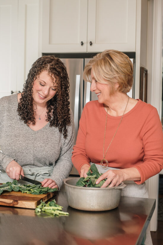 two women chopping collard greens