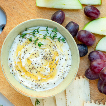 goat cheese and honey on board with fruit.