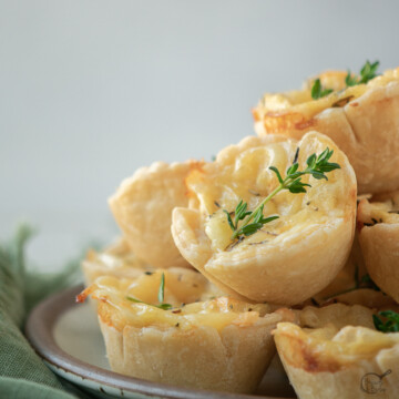 a few cheese tartlets on plate.