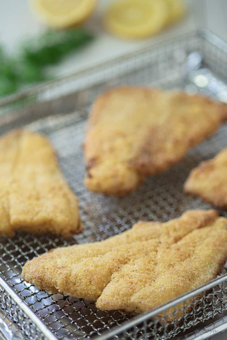 filets of air fryer catfish on basket with lemon