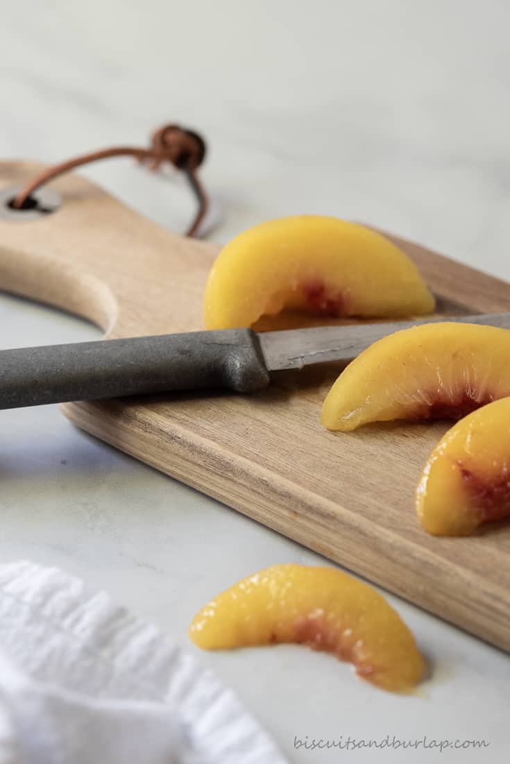 sliced peaches on cutting board