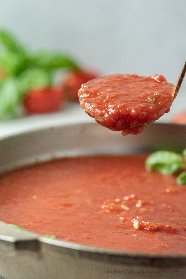 ladle of san marzo sauce over pan