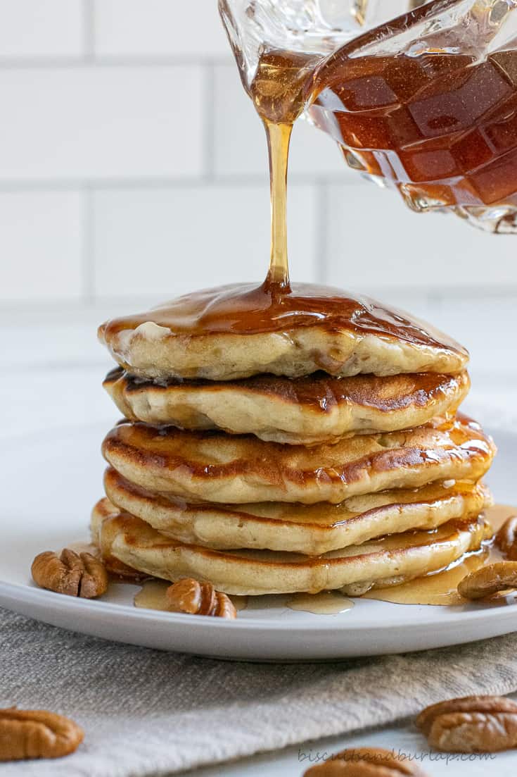 stack of banana buttermilk pancakes with syrup pour