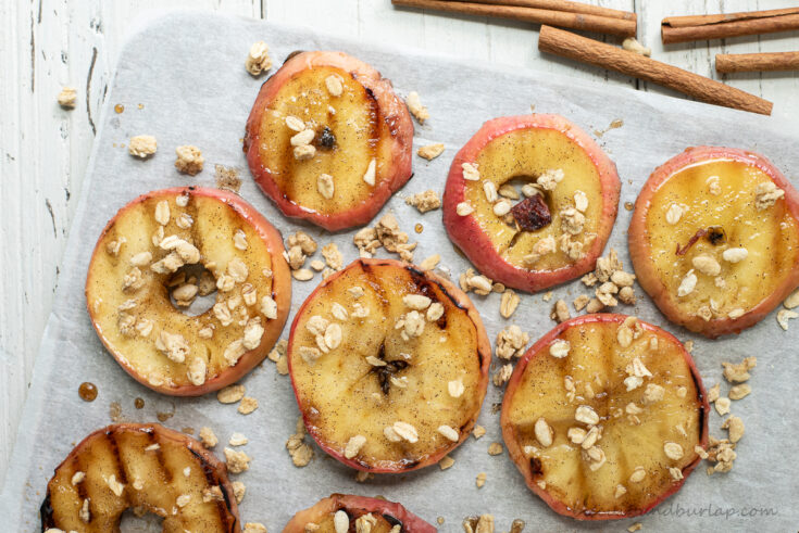 rows of grilled apples with granola and cinnamon sticks