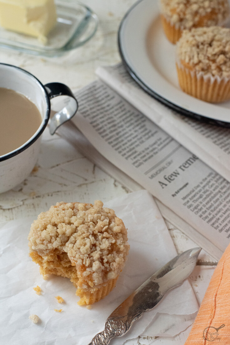 muffin with bite out, coffee & newspaper