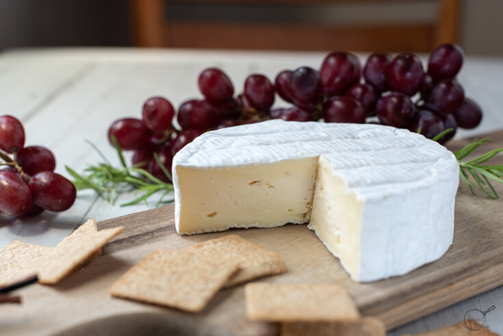 wheel of camembert with crackers and grapes