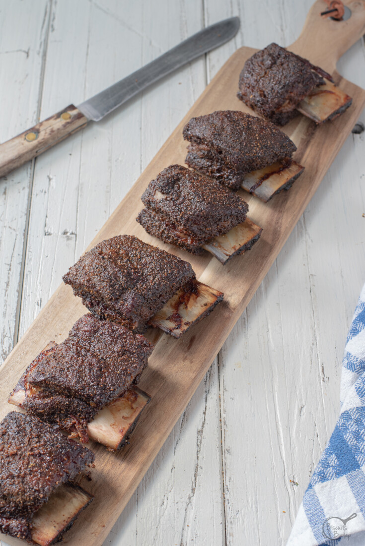 row of smoked beef short ribs on cutting board