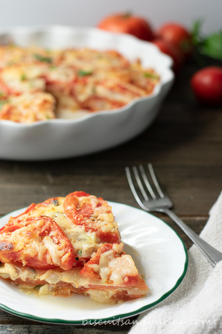 slice of tomato pie with whole pie behind