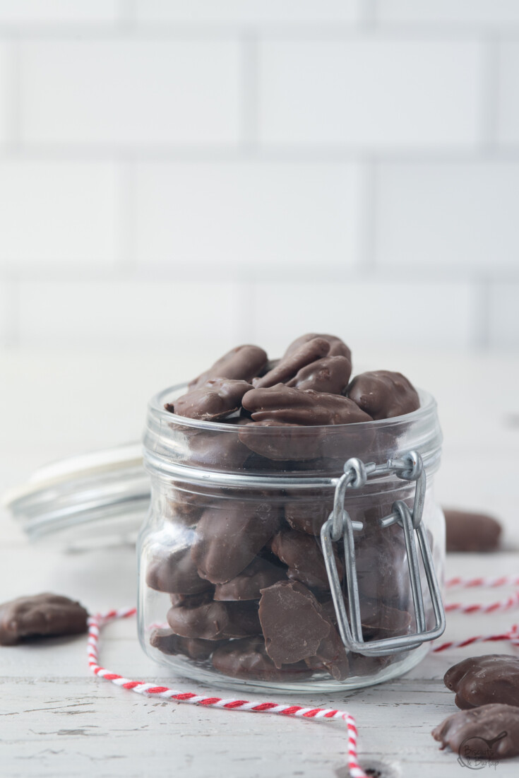 Covered jar open with chocolate covered pecans