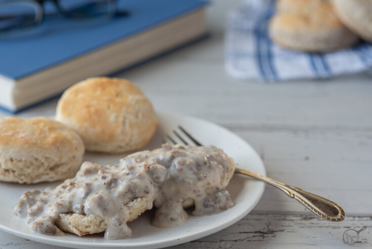 open biscuits with gravy over and book behind