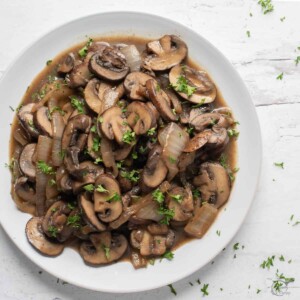 square photo of sauteed onions and mushrooms in white plate