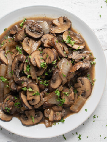 square photo of sauteed onions and mushrooms in white plate
