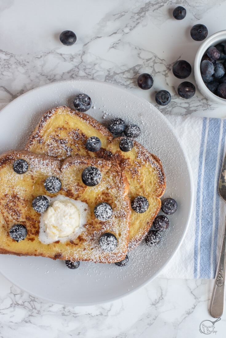 overhead shot of french toast with blueberries and butter melting.