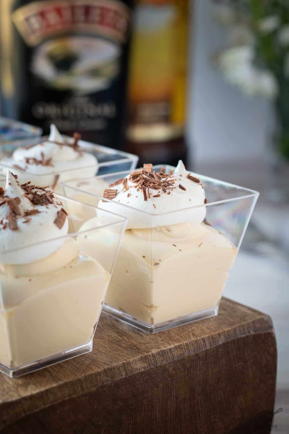 Mudslide Pudding Shots in square glasses on wooden block.