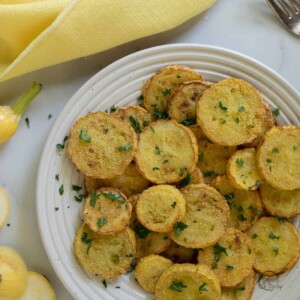 white plate with fried squash and yellow napkin.