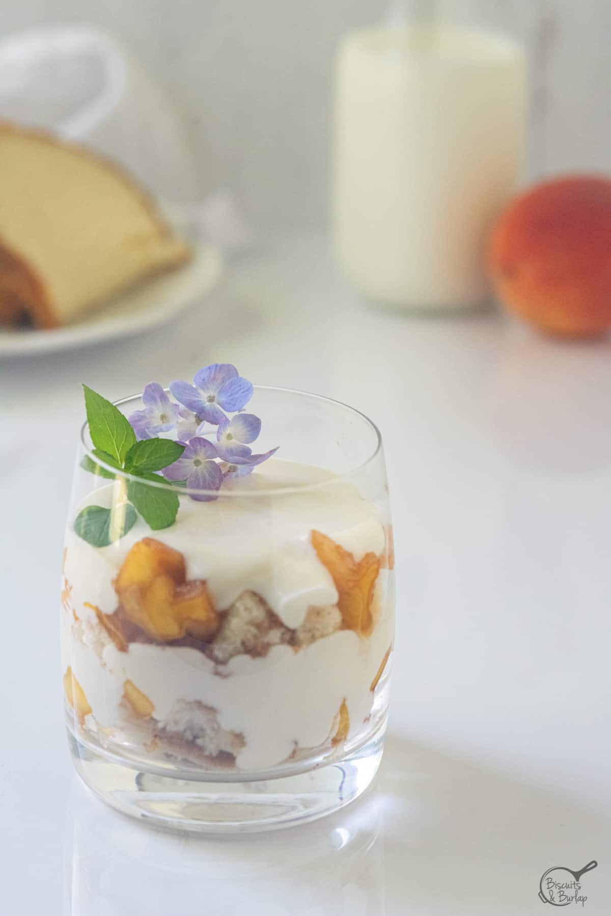 one peach trifle mini sized with mint and flower on top.